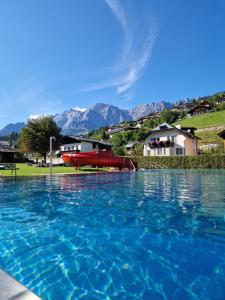een groot zwembad van blauw water met een boot erin bij Tauernlodge Sonnblick Top 2 in Mühlbach am Hochkönig