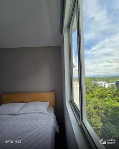 een slaapkamer met een bed en een groot raam bij Apartamento en Armenia - Edificio Ambar - Con Piscina - By Molca Travel in Armenia
