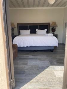 a bedroom with a large bed with white sheets at 17 Zurich Drive House in Margate