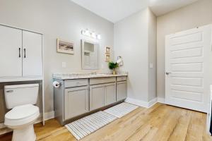 a bathroom with a toilet and a sink with a mirror at Seaglass Cottage in Rockport +14 photos