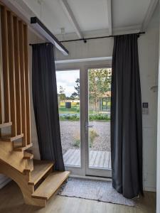a sliding glass door in a room with a staircase at Svencele K12 in Svencelė