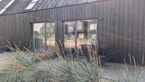 a black building with two windows and some grass at Svencele K12 in Svencelė