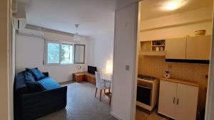 a kitchen and a living room with a couch and a table at Appartamenti "Venus" a Marina Julia per 4 o 6 persone in Marina Julia