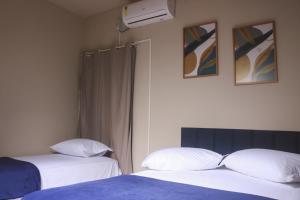 Dos camas una al lado de la otra en un dormitorio. en Pousada Vilas do Frances, en Marechal Deodoro