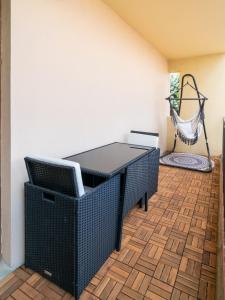 a patio with a table and a hammock in a room at Suite Zen - Calme et Lumière - 2 lits 160 cm - Parking privé résidence in Sélestat +4 photos