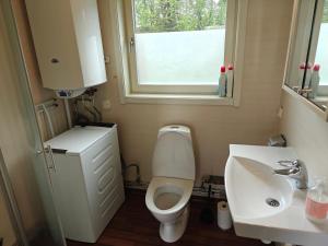 a bathroom with a toilet and a sink and a window at Stuga Dundret, Lappland in Gällivare