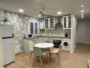 a kitchen with a table and chairs and a refrigerator at La Palentina in Palencia