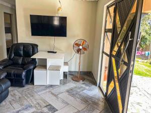 a living room with a tv and a chair and a table at 17 Zurich Drive House in Margate