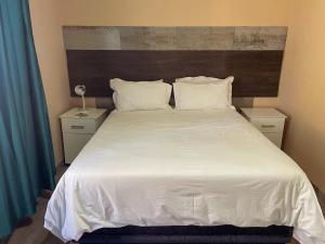 a bedroom with a large bed with white sheets and pillows at 17 Zurich Drive House in Margate