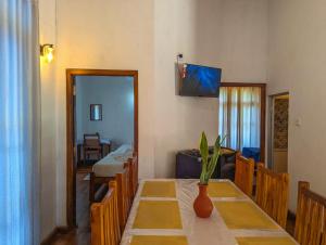 a dining room with a table with a vase on it at Gold Field Villa in Koslanda