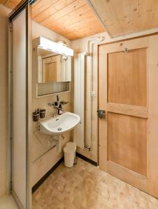 a bathroom with a sink and a wooden door at Maison rustique au cœur de la nature - Jaun, Charmey in Im Fang +29 photos
