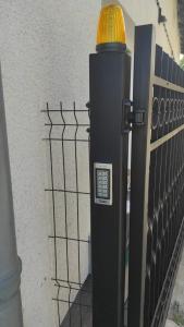 eine Parkuhr neben einer Mauer mit einem Zaun in der Unterkunft Dworskiego 74, Apartament 2 in Przemyśl
