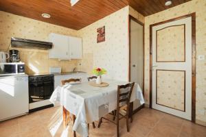 a kitchen with a table with a vase of flowers on it at La petite maison in Monthault