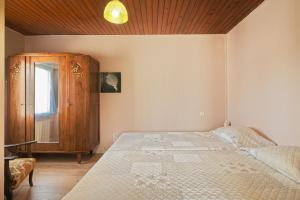 a bedroom with a bed and a wooden ceiling at La petite maison in Monthault