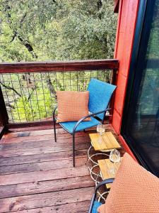 a blue chair sitting on a deck with a table at The Falls-Overlooks a waterfall-BBQ-Sleeps 4 in Oakhurst