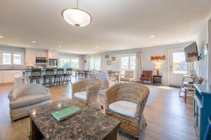 a living room with a table and chairs and a kitchen at Laughing Place - Southern Shores, 175 Ft to Beach, Pool Table, Pets OK, Flex Stays in Southern Shores