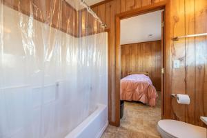 a bathroom with a tub and a toilet and a bed at Laughing Place - Southern Shores, 175 Ft to Beach, Pool Table, Pets OK, Flex Stays in Southern Shores +48 photos