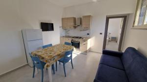 a kitchen and dining room with a table and blue chairs at Il cedro blu in Santa Maria del Cedro