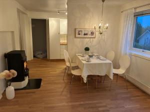 a dining room with a white table and chairs at Cozy apartment in Tromsø