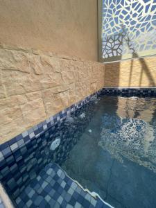 a swimming pool with a tiled floor and a window at Dar Diaft'na in Marrakesh