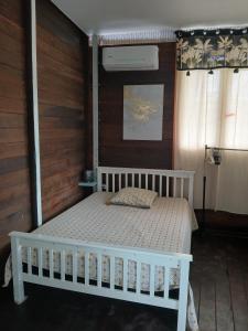 a bedroom with a white bed in a room at Magnifique Carbet in Roura