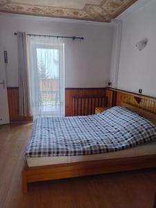 a bedroom with a bed with a blue plaid blanket at Villa Górski Spokój in Srebrna Góra