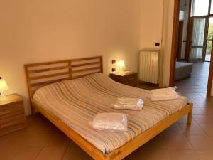 a bed in a bedroom with two night stands and two tables at Il Rifugio in San Giacomo degli Schiavoni