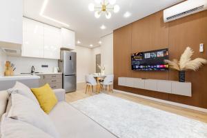 TaldykolʼにあるАпартаменты, в которые хочется возвращатьсяの白いソファとキッチンのあるリビングルーム