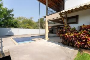a patio with a swimming pool and a house at Casa com piscina até 8 pessoas 10 minutos da Oktoberfest in Blumenau