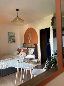 ein Wohnzimmer mit einem Bett und einem Tisch in der Unterkunft Studio cosy proche des plages, balcon, clim, fibre, & parking, Tout confort in Toulon