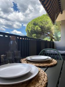 ein Tisch mit weißen Tellern darauf in der Unterkunft Studio cosy proche des plages, balcon, clim, fibre, & parking, Tout confort in Toulon + 21 Fotos