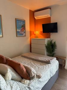 ein Schlafzimmer mit zwei Betten und einem Flachbildfernseher in der Unterkunft Studio cosy proche des plages, balcon, clim, fibre, & parking, Tout confort in Toulon