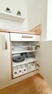 a kitchen cabinet with plates and dishes in it at Benmey Apartment Küche,TV,Waschmaschine in MHG +16 photos