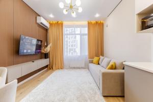 TaldykolʼにあるАпартаменты, в которые хочется возвращатьсяのソファとテレビのあるリビングルーム