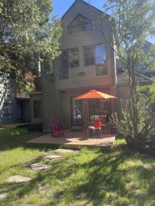 a house with a patio with an umbrella and chairs at perfect 'lil condo in Mont-Tremblant +5 photos