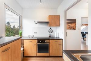 a kitchen with wooden cabinets and a stove top oven at Zwischen den Wellen in Oldenburg in Holstein