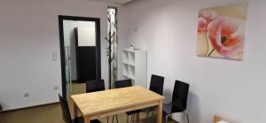 a dining room with a wooden table and black chairs at Żołnierska Hostel in Leszno