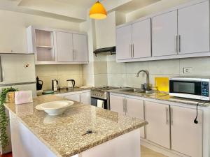 アディスアベバにあるAmazing 2BR with a View in Boleの白いキャビネットとカウンタートップを備えたキッチン