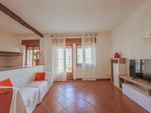 a living room with a white couch and a television at La Casa di Dario - Super Luminosa - 5' dal mare in Albinia