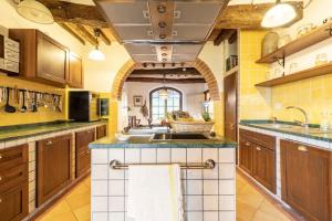 a large kitchen with wooden cabinets and a sink at Villa San Lorenzo - Lux Gated Estate/Private Pool in Gioiella +68 photos