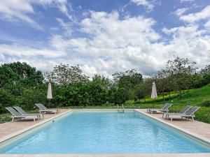 a swimming pool with two lawn chairs and umbrellas at Villa San Lorenzo - Lux Gated Estate/Private Pool in Gioiella
