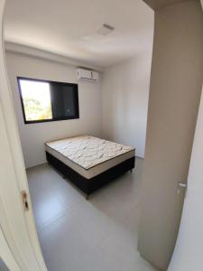 a bedroom with a bed in a room with a window at Apartamento Le Vert in Barretos