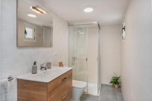 Un baño con inodoro, lavabo y ducha. en Apartamentos Callao, en Playa Quemada 37 fotos más