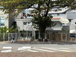 a man walking down a street in front of a building at Pousada Praia Pajuçara in Maceió