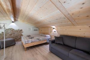 una sala de estar con una cama y un sofá en Lo Sarvanot, en Bernezzo 78 fotos más