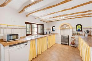 eine Küche mit weißen Wänden und gelben Vorhängen in der Unterkunft Casa rural Furones in Villanueva de Algaidas