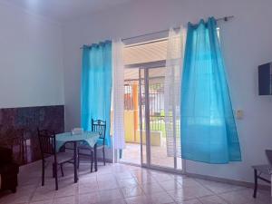 a dining room with a table and blue curtains at CasaLoca Cabarete Studio Apartment in Cabarete