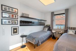 Un dormitorio con una cama y una silla y una ventana. en Baden - Baden international, en Baden-Baden