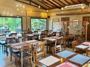 a dining room with wooden tables and chairs at Pousada Guata Porã in Foz do Iguaçu