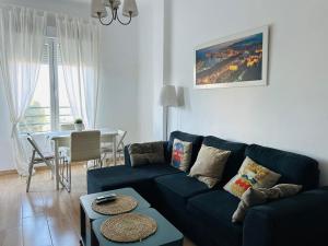 a living room with a blue couch and a table at Solymar Beach Premium in Málaga